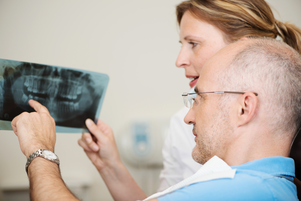 Dentist and patient are looking at x-rays