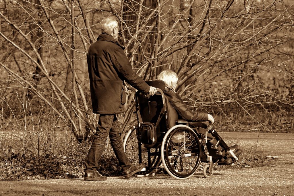 man pushing wheelchair