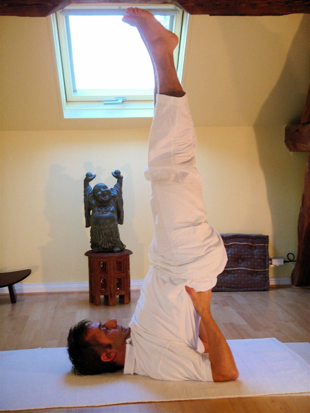 man doing a should stand yoga pose